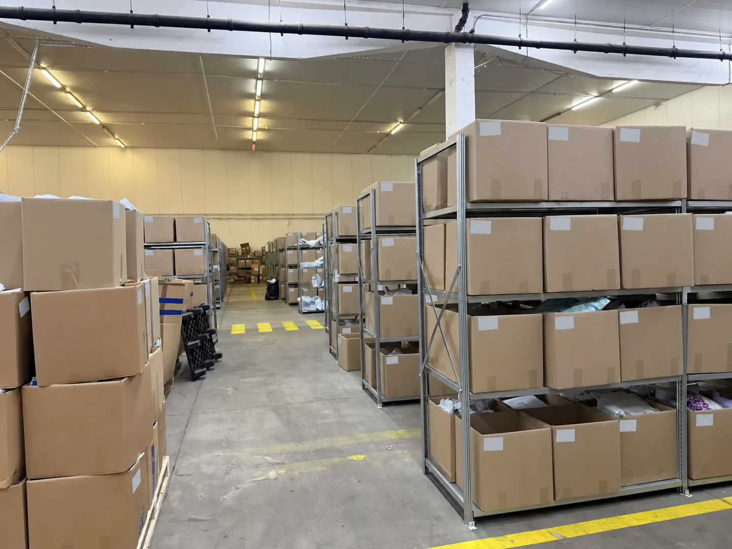 Cartons on warehouse shelves with package labels covered for privacy