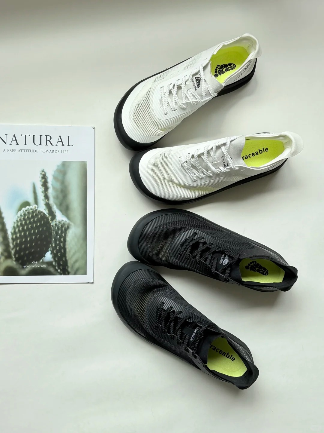 White and black Traceable shoes arranged on a light surface